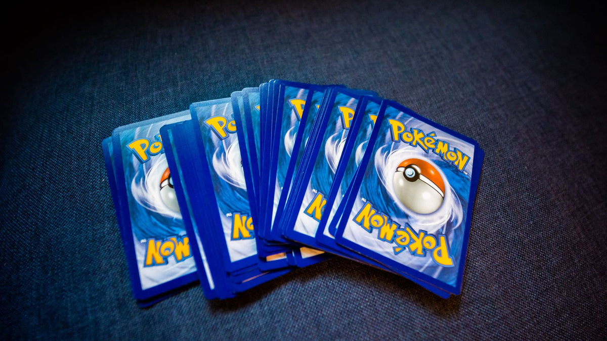 Stack of Pokémon cards fanned out on a dark surface