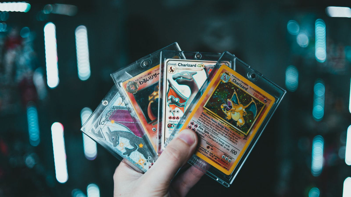 Collector holding graded Charizard Pokémon card slabs